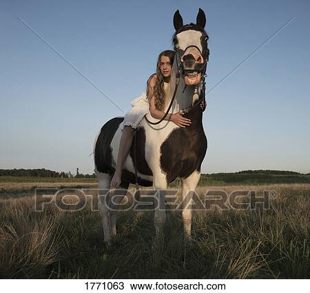 Portrait girl laying on horse in rural field View Large Photo Image Stock Image - Portrait girl laying on horse in rural field. Fotosearch