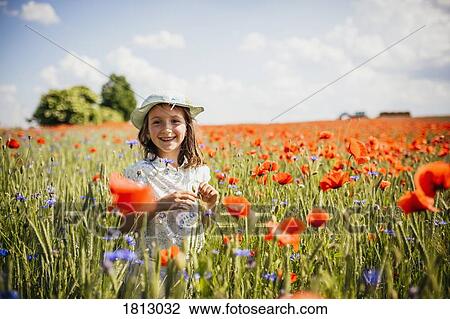 Portrait happy, carefree girl in sunny, idyllic rural red poppy field View Large Photo Image Stock Image - Portrait happy, carefree girl in sunny, idyllic rural red poppy field. Fotosearch