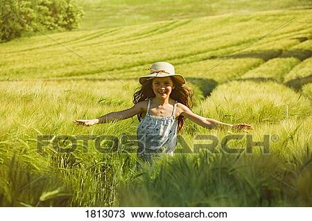 Stock Image - Portrait happy, carefree girl running sunny rural field. Fotosearch