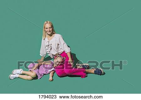 Portrait mother and daughter relaxing on green background View Large Photo Image Stock Image - Portrait mother and daughter relaxing on green background. Fotosearch