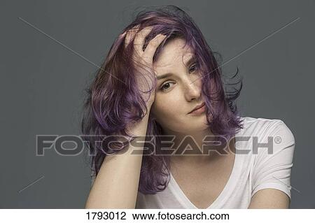 Portrait of a confident young woman with dyed and tousled hair against gray background View Large Photo Image Stock Image - Portrait of a confident young woman with dyed and tousled hair against gray background. Fotosearch