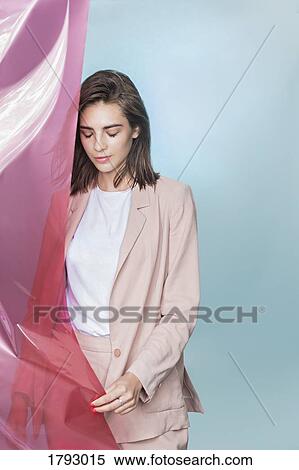 Portrait of a female fashion model posing with pink fabric and looking down View Large Photo Image Stock Photography - Portrait of a female fashion model posing with pink fabric and looking down. Fotosearch