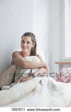 Portrait of beautiful woman sitting with blanket on bed at home View Large Photo Image Stock Image - Portrait of beautiful woman sitting with blanket on bed at home. Fotosearch