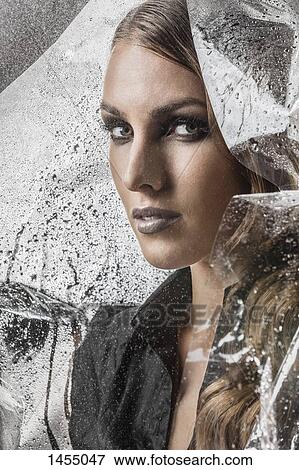 Portrait of beautiful woman wrapped in plastic against black background View Large Photo Image Stock Photo - Portrait of beautiful woman wrapped in plastic against black background. Fotosearch