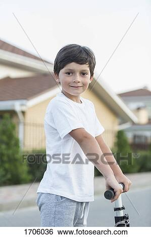 Portrait of boy with push scooter in town View Large Photo Image Stock Photograph - Portrait of boy with push scooter in town. Fotosearch