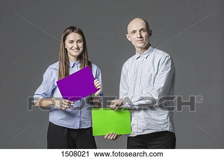 Portrait of business people holding placards against gray background View Large Photo Image Stock Image - Portrait of business people holding placards against gray background. Fotosearch