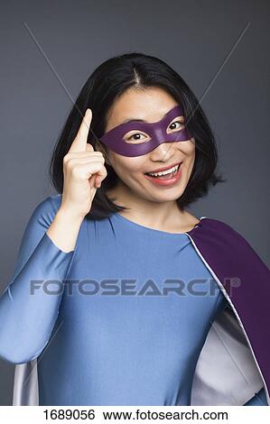 Portrait of cheerful female superhero gesturing while standing against gray background View Large Photo Image Stock Photograph - Portrait of cheerful female superhero gesturing while standing against gray background. Fotosearch