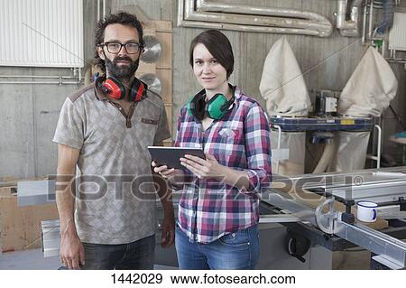 Stock Photo - Portrait of confident carpenters with digital tablet in workshop. Fotosearch