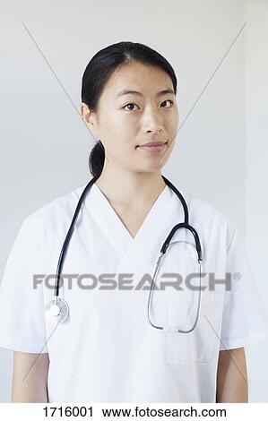 Portrait of confident doctor standing against white wall View Large Photo Image Stock Image - Portrait of confident doctor standing against white wall. Fotosearch
