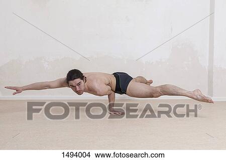 Portrait of confident man doing arm balance yoga exercises View Large Photo Image Picture - Portrait of confident man doing arm balance yoga exercises. Fotosearch