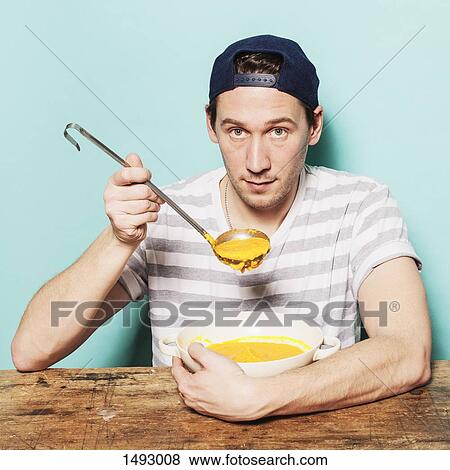 Portrait of confident man having pumpkin soup at table against blue background View Large Photo Image Stock Photo - Portrait of confident man having pumpkin soup at table against blue background. Fotosearch