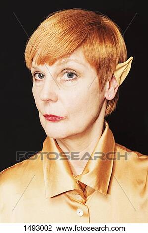 Portrait of confident mature woman wearing artificial pointy ear against black background View Large Photo Image Stock Image - Portrait of confident mature woman wearing artificial pointy ear against black background. Fotosearch