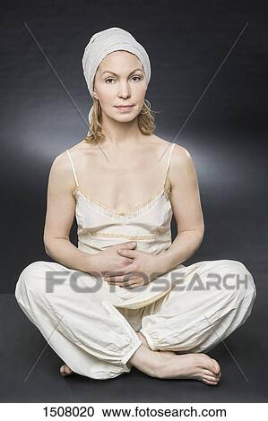Portrait of confident woman sitting against gray background View Large Photo Image Stock Image - Portrait of confident woman sitting against gray background. Fotosearch