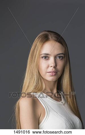 Portrait of confident woman with long hair against gray background View Large Photo Image Stock Photograph - Portrait of confident woman with long hair against gray background. Fotosearch