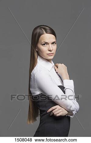 Portrait of confidentwoman standing against gray background View Large Photo Image Stock Photo - Portrait of confidentwoman standing against gray background. Fotosearch