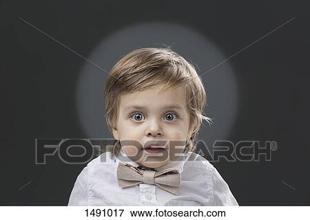 Portrait of cute boy with bowtie against gray background View Large Photo Image Stock Photo - Portrait of cute boy with bowtie against gray background. Fotosearch