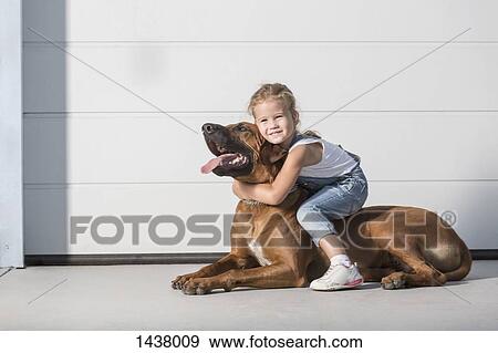 Portrait of cute girl sitting on dog outdoors View Large Photo Image Stock Photo - Portrait of cute girl sitting on dog outdoors. Fotosearch