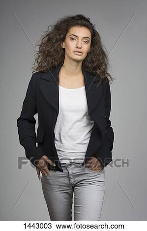 Portrait of fashionable young woman walking against gray background View Large Photo Image Stock Image - Portrait of fashionable young woman walking against gray background. Fotosearch