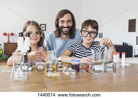 Portrait of father and children doing science experiment at home View Large Photo Image Picture - Portrait of father and children doing science experiment at home. Fotosearch
