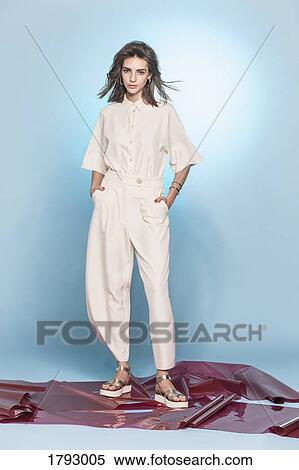 Portrait of female fashion model posing against blue background View Large Photo Image Stock Photography - Portrait of female fashion model posing against blue background. Fotosearch
