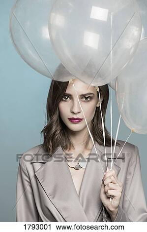 Portrait of female fashion model holding balloons View Large Photo Image Stock Image - Portrait of female fashion model holding balloons. Fotosearch