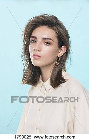 Stock Photography - Portrait of female fashion model against blue background. Fotosearch