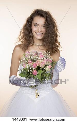 Portrait of happy bride holding bouquet against colored background View Large Photo Image Stock Image - Portrait of happy bride holding bouquet against colored background. Fotosearch
