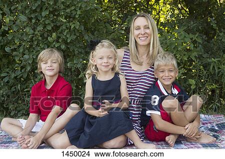Picture - Portrait of happy family sitting at backyard. Fotosearch
