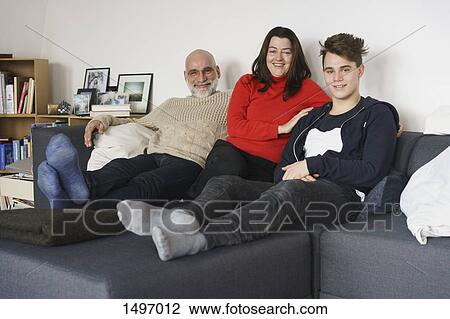 Portrait of happy family sitting on sofa at home View Large Photo Image Stock Image - Portrait of happy family sitting on sofa at home. Fotosearch