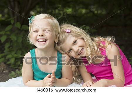 Portrait of happy girl leaning on sister at backyard View Large Photo Image Stock Photography - Portrait of happy girl leaning on sister at backyard. Fotosearch