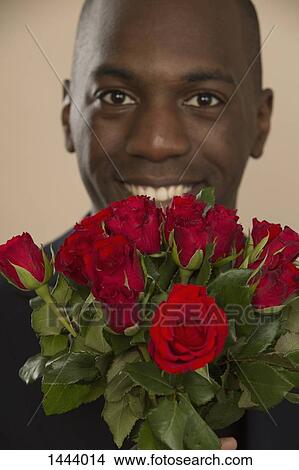 Picture - Portrait of happy man with roses against colored background. Fotosearch