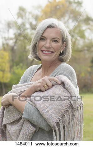 Portrait of happy mature woman standing at park during autumn View Large Photo Image Stock Image - Portrait of happy mature woman standing at park during autumn. Fotosearch