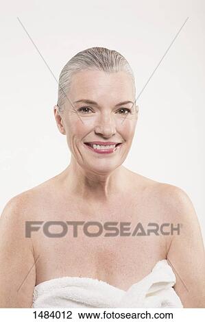 Portrait of happy mature woman wrapped in towel against white background View Large Photo Image Stock Image - Portrait of happy mature woman wrapped in towel against white background. Fotosearch