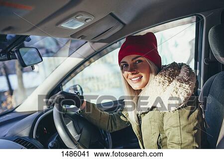 Portrait of happy woman in warm clothing driving car View Large Photo Image Stock Image - Portrait of happy woman in warm clothing driving car. Fotosearch