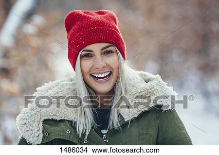 Portrait of happy young woman standing outdoors during winter View Large Photo Image Picture - Portrait of happy young woman standing outdoors during winter. Fotosearch