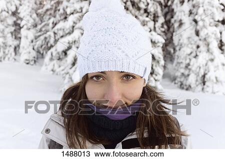 Stock Image - Portrait of happy young woman wearing knit hat outdoors. Fotosearch