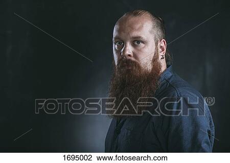 Stock Image - Portrait of hipster against gray background. Fotosearch