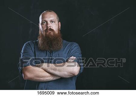 Portrait of hipster standing with arms crossed against black background View Large Photo Image Stock Photo - Portrait of hipster standing with arms crossed against black background. Fotosearch