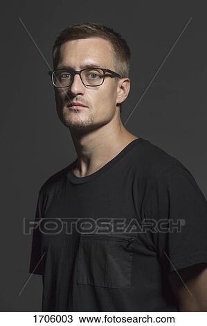Portrait of mid adult man wearing eyeglasses standing against gray background View Large Photo Image Stock Image - Portrait of mid adult man wearing eyeglasses standing against gray background. Fotosearch