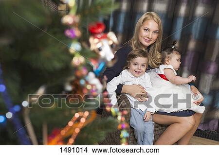 Picture - Portrait of mother sitting with son and daughter celebrating Christmas. Fotosearch