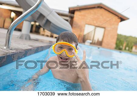 Portrait of shirtless boy showing peace sign while swimming in pool View Large Photo Image Stock Photo - Portrait of shirtless boy showing peace sign while swimming in pool. Fotosearch