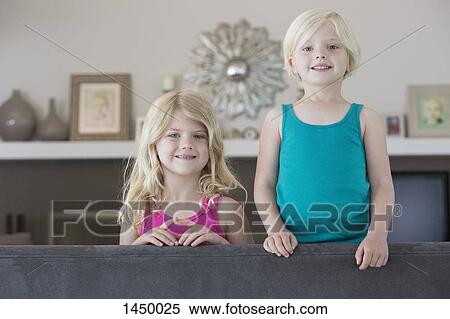 Portrait of sisters on sofa at home View Large Photo Image Stock Photography - Portrait of sisters on sofa at home. Fotosearch