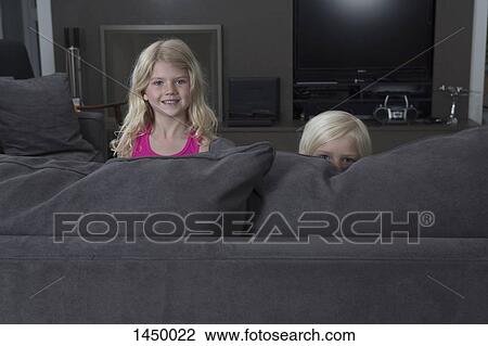 Portrait of sisters peeking over sofa at home View Large Photo Image Stock Image - Portrait of sisters peeking over sofa at home. Fotosearch