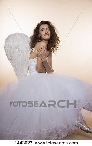 Portrait of smiling bride wearing angel wings against colored background View Large Photo Image Stock Photo - Portrait of smiling bride wearing angel wings against colored background. Fotosearch