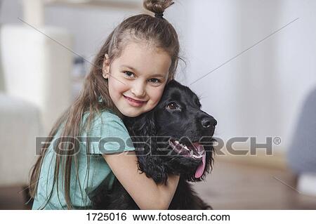 Portrait of smiling girl embracing Cocker Spaniel at home View Large Photo Image Stock Photograph - Portrait of smiling girl embracing Cocker Spaniel at home. Fotosearch