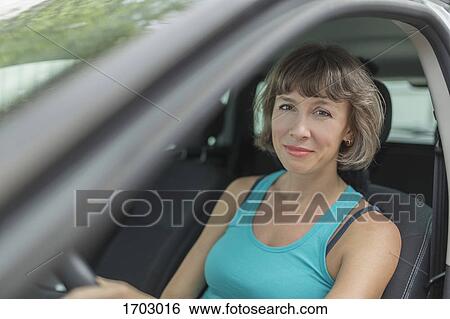 Portrait of smiling mature woman sitting in car View Large Photo Image Stock Photograph - Portrait of smiling mature woman sitting in car. Fotosearch