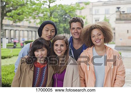 Portrait of smiling multi-ethnic young friends standing outdoors View Large Photo Image Stock Photography - Portrait of smiling multi-ethnic young friends standing outdoors. Fotosearch