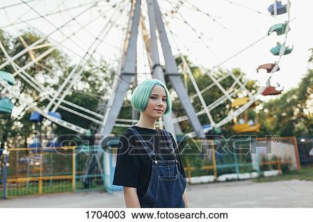 Portrait of smiling teenage girl standing against Ferris wheel at park View Large Photo Image Stock Image - Portrait of smiling teenage girl standing against Ferris wheel at park. Fotosearch