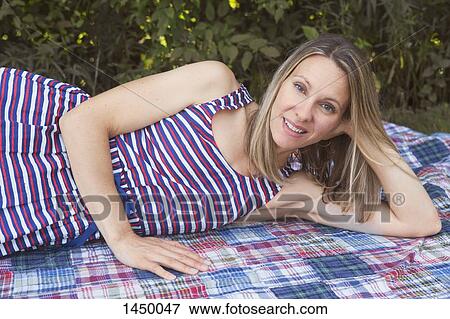 Portrait of smiling woman relaxing on sheet in backyard View Large Photo Image Stock Photo - Portrait of smiling woman relaxing on sheet in backyard. Fotosearch
