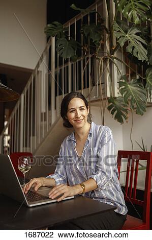 Portrait of smiling young woman using laptop at home View Large Photo Image Stock Image - Portrait of smiling young woman using laptop at home. Fotosearch